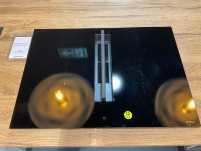 une assiette en verre noir sur laquelle sont posées deux bougies jaunes