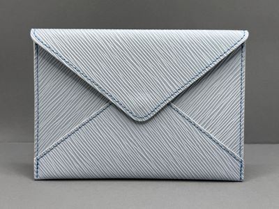 une enveloppe blanche ornée d'une couture bleue
