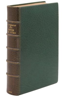 un vieux livre à la couverture verte posé sur une surface blanche