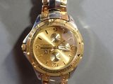 wrist watch with a gold dial and two tone bracelet