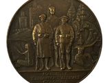 une médaille de bronze sur laquelle figurent trois hommes