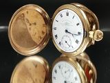 une montre de poche en or posée sur une table noire