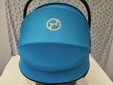 a blue baby stroller sitting on top of a white chair