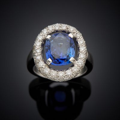 an oval blue sapphire and diamond ring on a black surface