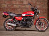a red motorcycle parked in front of a brick wall