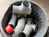 a bucket full of pipes sitting on the floor