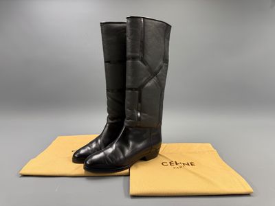 une paire de bottes noires posées sur un tissu jaune