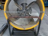 a yellow fan sitting on top of a metal stand in a warehouse