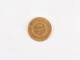 a close up of a gold coin on a white surface