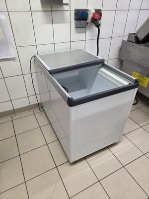 un congélateur posé au milieu d'un sol carrelé