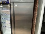 a silver refrigerator in the middle of a tiled floor