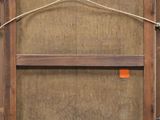 an old wooden frame with a rope hanging from it ' s side