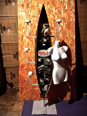un mannequin blanc avec une planche de surf posée sur un support