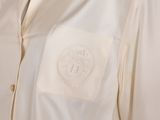 a close up of a white shirt with a monogram on it