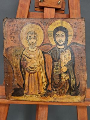 an old wooden easel with a painting of two people on it