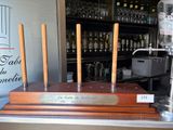 a wooden table with four candles and a bottle of wine on it