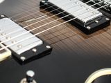 a close up of an electric guitar with a white background