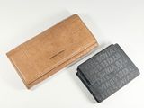 two leather wallets sitting next to each other on a white surface