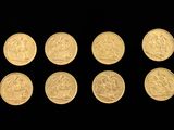 six gold coins are arranged in a row on a black background
