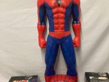 a spider man figurine with various toys on a table