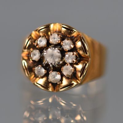 un gros plan d'une bague en or sertie de diamants sur une surface réfléchissante