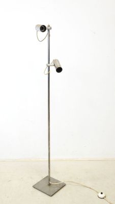 a metal floor lamp with two lights on top of it