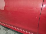 the door panel of a red car with the door handle missing