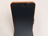 l'arrière d'un téléphone portable noir et orange posé sur un support