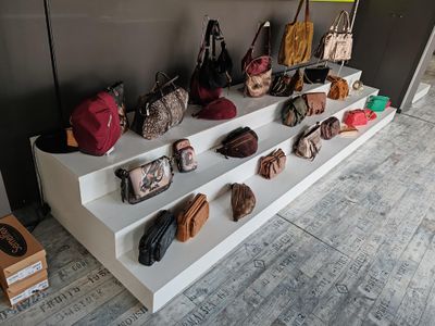 a display of purses and handbags on a white shelf