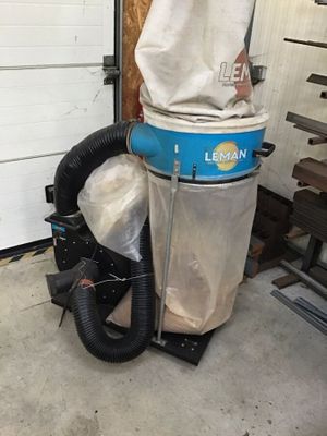 un dépoussiéreur installé dans un garage, surmonté d'un sac