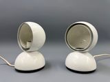 two white lamps sitting on top of a table next to each other