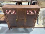 a wooden cabinet that has a pink and white design on it