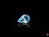 a blue diamond on a black surface with a reflection