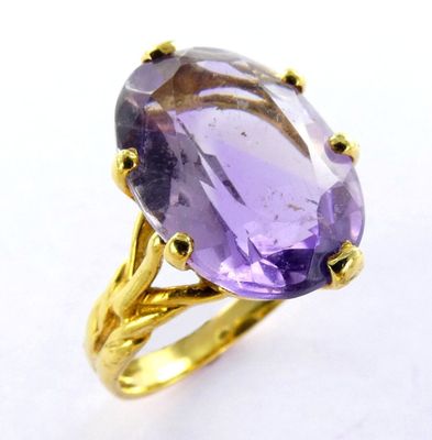 une image représentant une bague en pierre violette rehaussée de touches dorées sur un fond blanc
