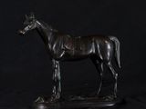 a statue of a horse that is standing on a black surface
