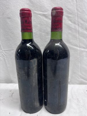 two bottles of wine sitting on top of a white table