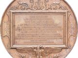 an image of a bronze plaque with an eagle and a cross on it