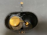 a black leather case with a metal object inside of it