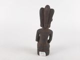a small wooden statue of a man with a hat on his head