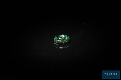 a close up of a green glass object on a black surface