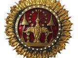 broche dorée et rouge représentant un homme à dos d'éléphant