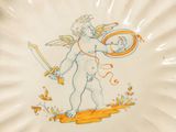 a plate with a picture of a cupid holding a tennis racquet