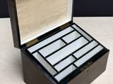 an old black and white box with a glass lid on a table