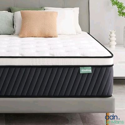 une photo d'un lit avec un matelas et des oreillers