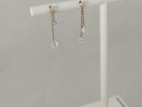 a pair of earrings on a white stand with a white background