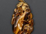 une image d'un pendentif en œil-de-tigre orné de feuilles