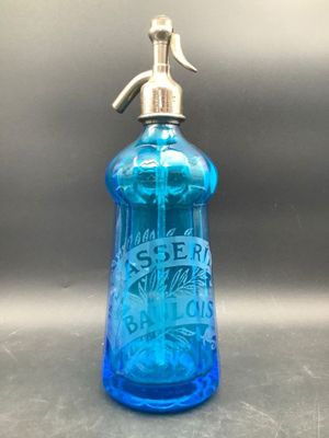 une image représentant une bouteille en verre bleue munie d'une poignée métallique