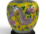 une image représentant un vase jaune orné d'un dragon et de fleurs