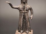une statue en bronze représentant une femme tendant la main