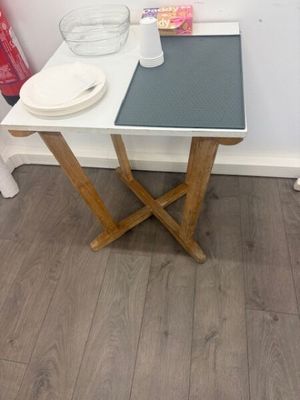 a small table with a bowl on it in the corner of a room